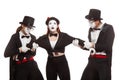 Portrait of three mime artists performing, isolated on white background. Two men pull the girl to sides, can not divide Royalty Free Stock Photo