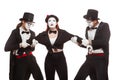 Portrait of three mime artists performing,  on white background. Two men pull the girl to sides, can not divide Royalty Free Stock Photo