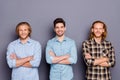 Portrait of three nice attractive content cheerful cheery guys folded arms wearing checked shirt isolated over gray Royalty Free Stock Photo