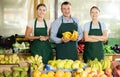 Portrait of three salespeople in the fruit and vegetable department of supermarket