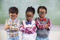 Portrait of three school kids standing against chalkboard