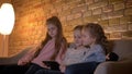 Portrait of three small caucasian girls watching into tablet with attentiveness and interest in cosy home atmosphere.