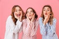 Portrait of three women friends wearing leisure clothing touching cheeks and smiling while enjoying girlish party during