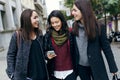 Portrait of three young beautiful women using mobile phone. Royalty Free Stock Photo