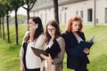 Portrait of three young successful businesswomen standing outdoors near office building on a sunny day. Royalty Free Stock Photo