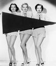 Portrait of three young women holding a banner and smiling Royalty Free Stock Photo