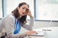 Portrait tired executive using laptop at desk