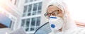 Portrait of tired exhausted female doctor, scientist or nurse wearing face mask and biological hazmat ppe suit reading Royalty Free Stock Photo