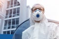 Portrait of tired exhausted pensive female doctor, scientist or nurse wearing face mask and biological hazmat ppe suit looking Royalty Free Stock Photo