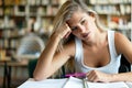 Portrait of a tired female student studying with books at the library Royalty Free Stock Photo