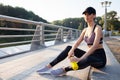 Portrait of tired fitness young woman outdoors in the city. Young woman runner resting after workout session on sunny