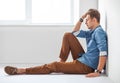 Portrait of tired handsome man sitting on the floor