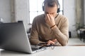 Handsome bearded guy wearing casual turtleneck using a laptop Royalty Free Stock Photo