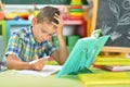 Portrait of schoolboy doing homework in classroom Royalty Free Stock Photo