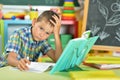 Portrait of tired schoolboy doing homework in classroom Royalty Free Stock Photo