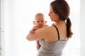 Mother with naked newborn on lighted white background