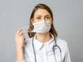 Portrait of tired young doctor taking off medical face mask Royalty Free Stock Photo