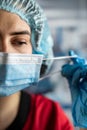 Portrait of tired young doctor taking off medical face mask after a shift in clinic Royalty Free Stock Photo