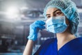 Portrait of tired young doctor taking off medical face mask after a shift in clinic Royalty Free Stock Photo