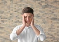 Portrait of tired young man against brick wall Royalty Free Stock Photo