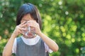 Portrait of a 4 to 6 year old Thai kid Asian girl with cute face holding a glass of water. She is drinking water to refresh her Royalty Free Stock Photo