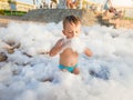 Portrait of cute toddler boy playing and having fun with lots of soap foam the beach disco party Royalty Free Stock Photo