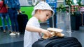 Portrait of little toddler boy playing with miniature wooden airplane in airport terminal Royalty Free Stock Photo