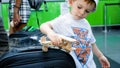 Portrait of cute toddler boy playing with wooden toy airplane in check-in line Royalty Free Stock Photo