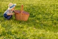 Toddler child outdoors. One year old baby boy wearing straw hat looking in picnic basket Royalty Free Stock Photo