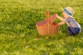 Toddler child outdoors. One year old baby boy wearing straw hat looking in picnic basket Royalty Free Stock Photo