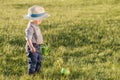 Toddler child outdoors. One year old baby boy wearing straw hat using watering can Royalty Free Stock Photo