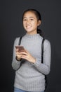 Portrait toothy smiling face of asian teenager with smart phone in hand