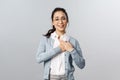 Portrait of touched, flattered young woman, teacher or office worker in glasses, hold hands on heart impressed with ncie