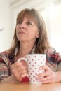 Portrait of toughtful mature woman holding a mug