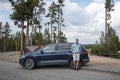 Portrait of tourist is standing by car at entrance of Yellowstone National Park