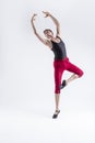 Portrait of Tranquil Contemporary Ballet of Flexible Athletic Man Posing in Red Tights in Ballanced Dance Pose With Hands Lifted