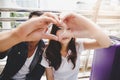 Portrait traveler couple. Handsome boyfriend and beautiful girlfriend is making symbol of love by using their hand and finger for