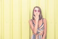 Hipster girl with sunglasses against colored wall on the street. Royalty Free Stock Photo