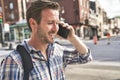 Portrait of a trendy young man in the city walking and speak on the phone Royalty Free Stock Photo