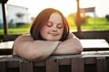 A Portrait of trisomie 21 adult girl outside at sunset