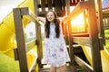 A portrait of trisomie 21 adult girl outside at sunset having fun on a park