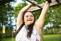 A Portrait of trisomie 21 adult girl outside at sunset having fun on a park