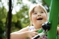 A portrait of trisomie 21 child girl outside having fun on a park