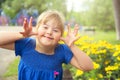 A portrait of trisomie 21 child girl outside having fun on a park giving some grim