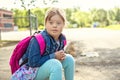 A portrait of trisomie 21 child girl outside on a school playground