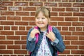 A portrait of trisomie 21 child girl outside on a school playground