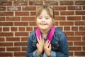 A portrait of trisomie 21 child girl outside on a school playground