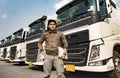 Portrait of Truck driver holding clipboard standing with modern semi truck. Royalty Free Stock Photo