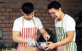 Portrait of two asian handsome men cooking together as hobby in kitchen room at home on holiday. Lifestyle, Friendship and LBGT Royalty Free Stock Photo