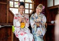 Portrait of two Asian women wear japanese style dress sit and enjoy in small shop and also hold small gift and look to camera with Royalty Free Stock Photo